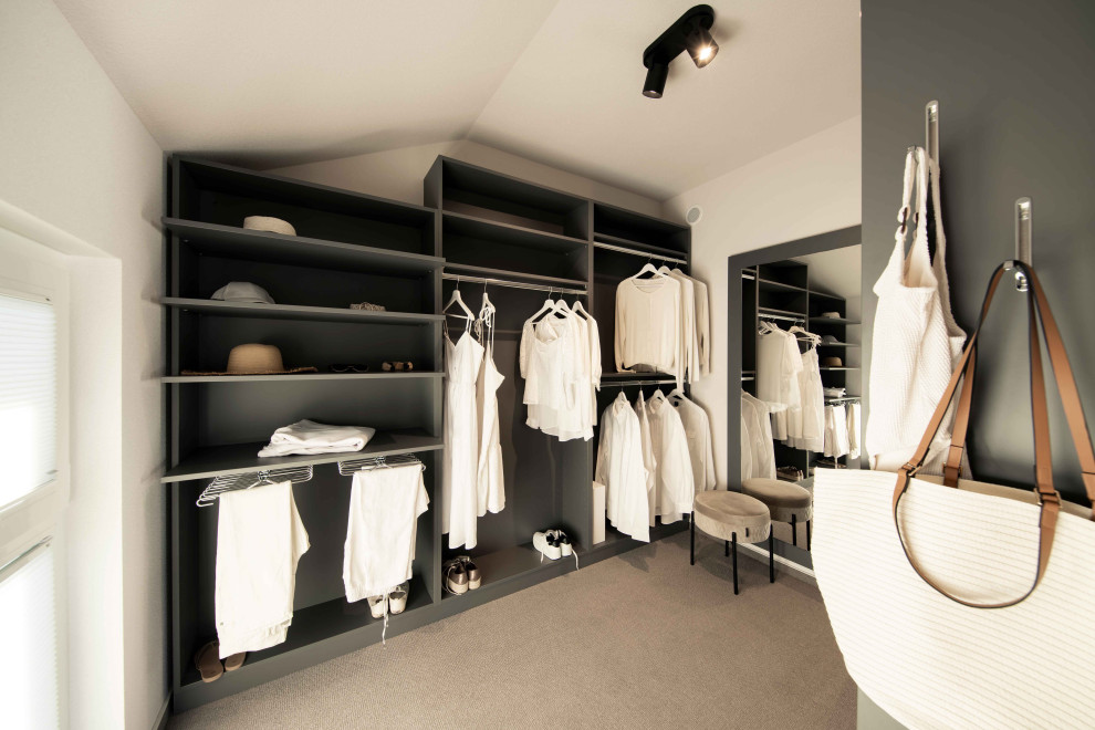 Immagine di un piccolo spazio per vestirsi unisex minimalista con nessun'anta, moquette e pavimento beige