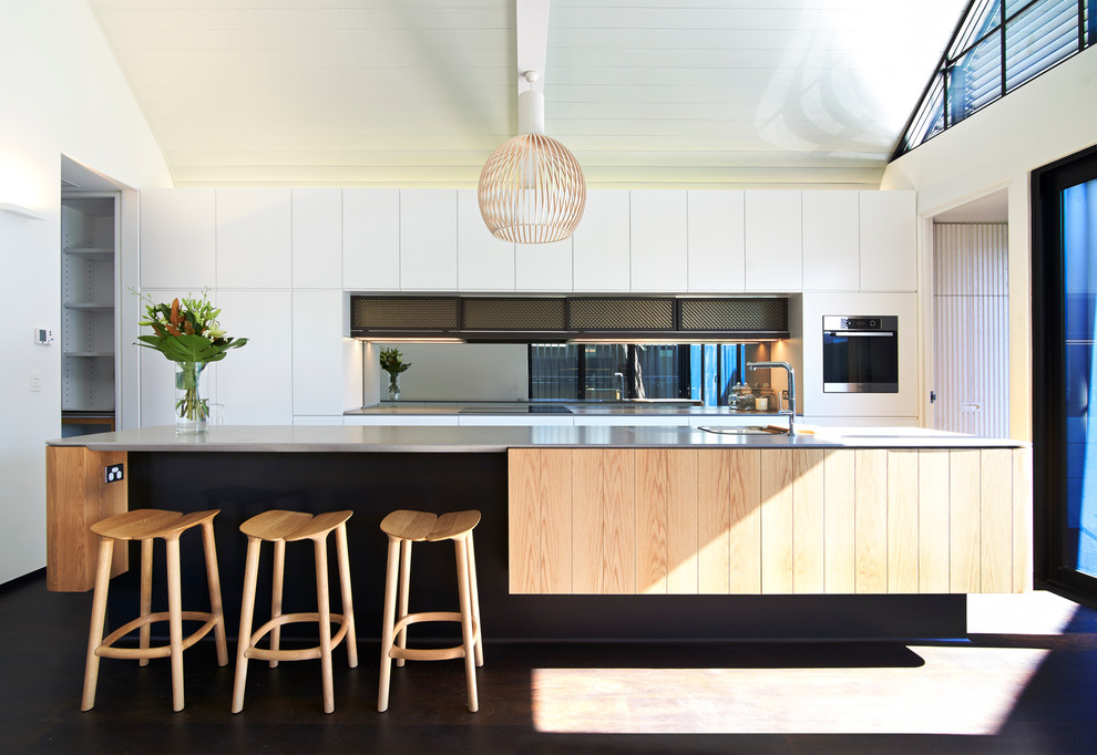 Large contemporary galley kitchen in Perth with a drop-in sink, flat-panel cabinets, white cabinets, stainless steel appliances, dark hardwood floors, mirror splashback and with island.