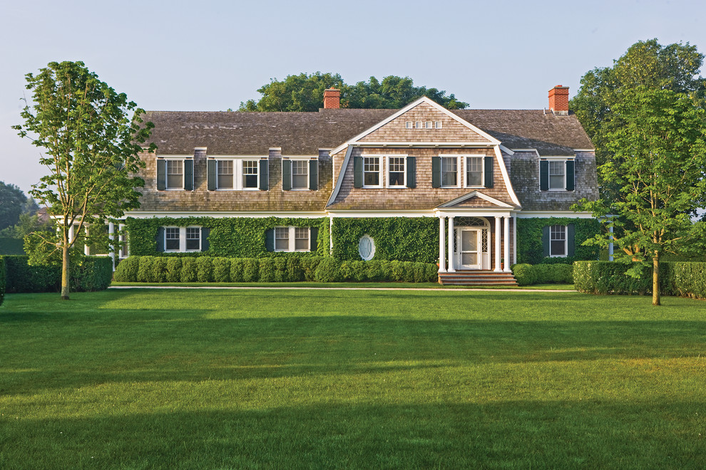 Expansive traditional two-storey exterior in New York with wood siding and a gambrel roof.