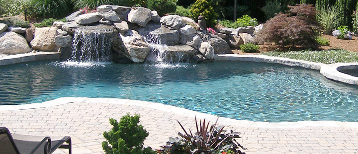 Inspiration for a mid-sized modern backyard custom-shaped pool in New York with a water feature and stamped concrete.