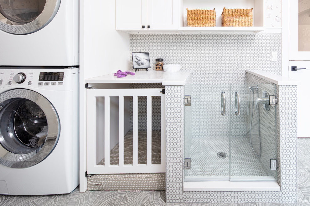 Utility room - mid-sized modern porcelain tile and gray floor utility room idea in Chicago with flat-panel cabinets, white cabinets, quartz countertops, a stacked washer/dryer and white countertops