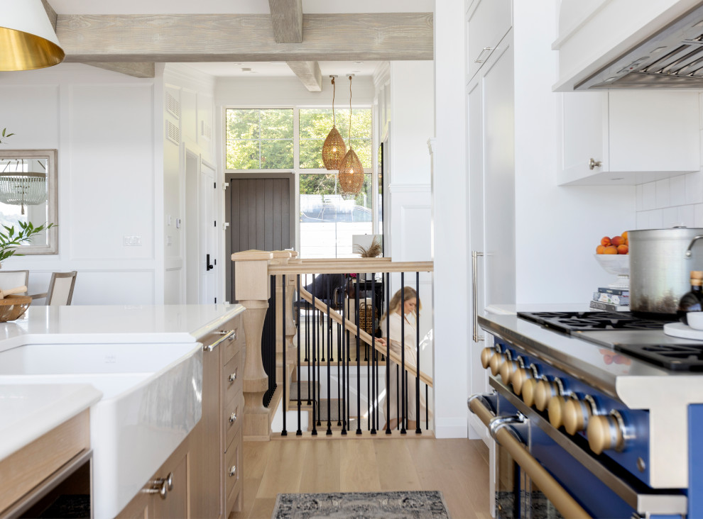 Immagine di una cucina stile marinaro con lavello stile country, parquet chiaro, pavimento beige e travi a vista