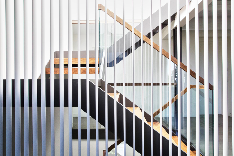 This is an example of a mid-sized modern wood floating staircase in San Francisco with open risers.