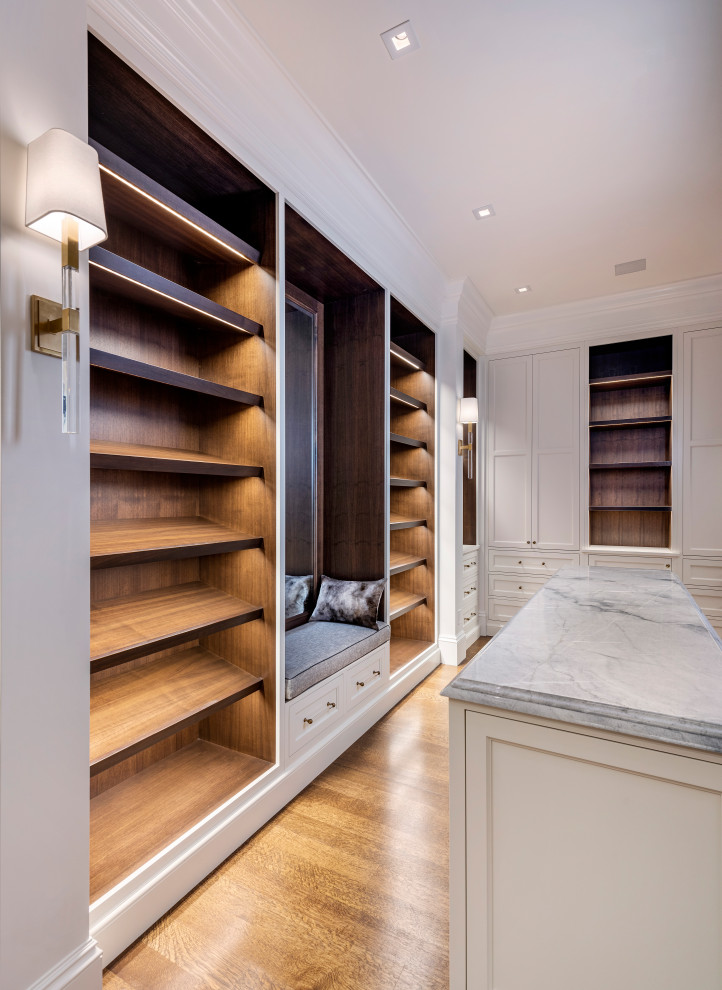 Transitional gender-neutral dressing room in Boston with recessed-panel cabinets, white cabinets and medium hardwood floors.