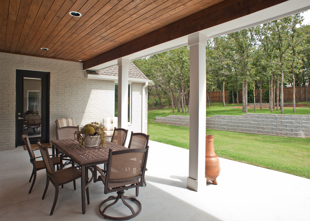 Example of a large transitional backyard concrete paver patio kitchen design in Oklahoma City with a roof extension