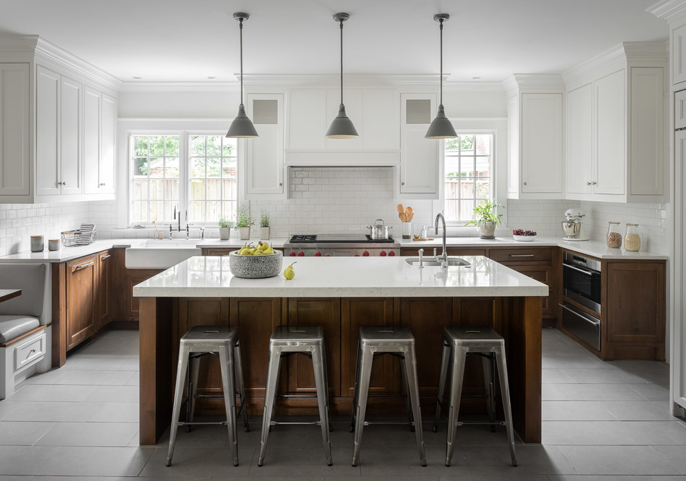 Design ideas for a large beach style u-shaped eat-in kitchen in Atlanta with a farmhouse sink, shaker cabinets, white cabinets, quartz benchtops, white splashback, subway tile splashback, ceramic floors, with island, grey floor, white benchtop and stainless steel appliances.