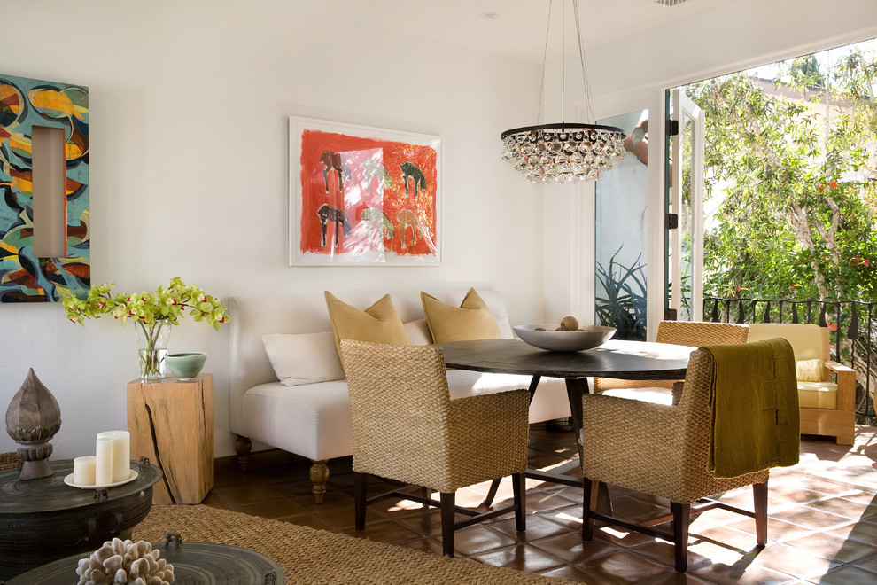 Mid-sized mediterranean open plan dining in Santa Barbara with white walls and terra-cotta floors.