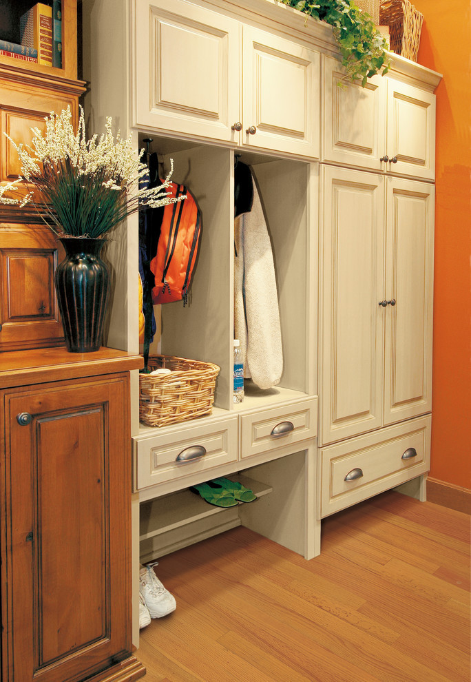 Inspiration for a small traditional mudroom in Seattle with orange walls, medium hardwood floors and brown floor.