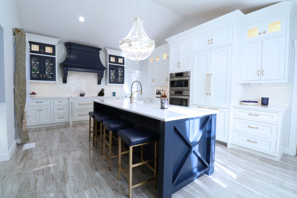 Photo of a mid-sized country l-shaped eat-in kitchen in Boston with a farmhouse sink, beaded inset cabinets, blue cabinets, quartz benchtops, white splashback, porcelain splashback, panelled appliances, porcelain floors, with island, grey floor, white benchtop and vaulted.