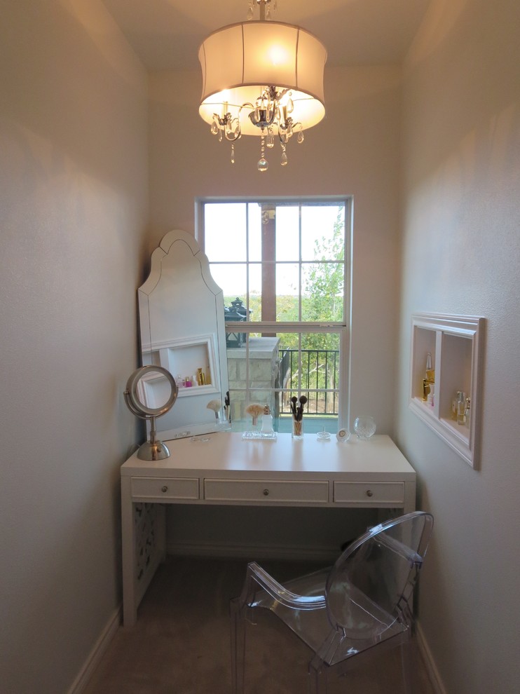 Large transitional women's dressing room in Austin with white cabinets and carpet.