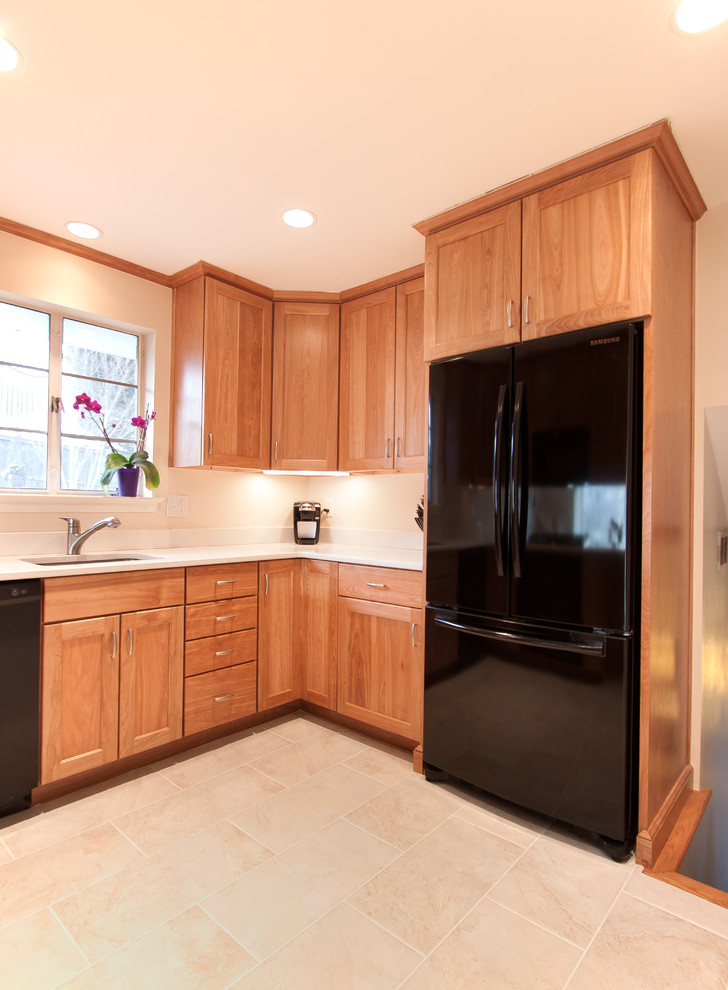 This is an example of a small contemporary u-shaped kitchen in DC Metro with an undermount sink, quartz benchtops, black appliances, ceramic floors and a peninsula.