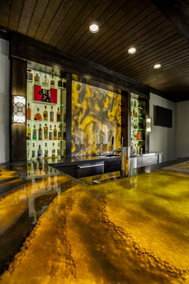 This is an example of an expansive contemporary u-shaped seated home bar in Dallas with an undermount sink, open cabinets, dark wood cabinets, onyx benchtops, yellow splashback, stone slab splashback and dark hardwood floors.