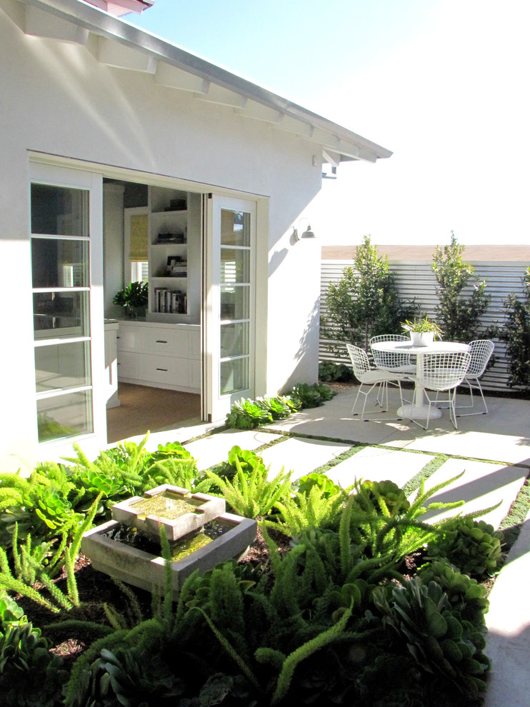 Beach style patio in Orange County with a water feature.