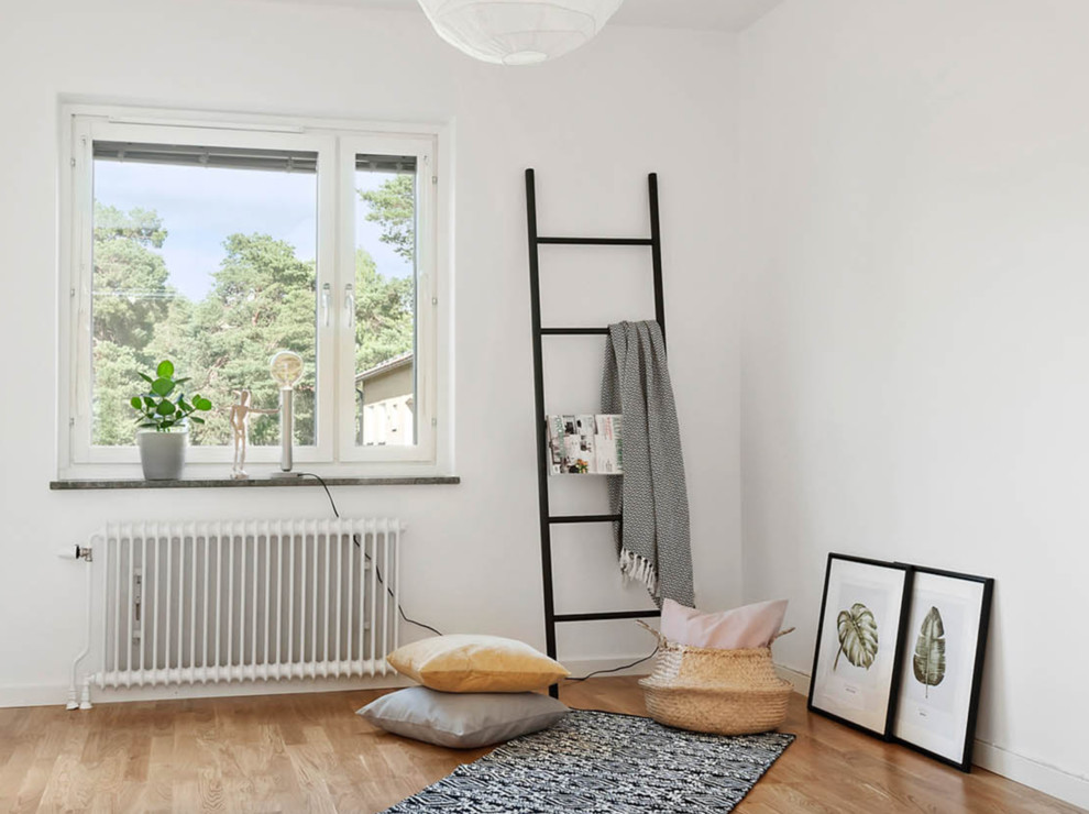 This is an example of a small scandinavian master bedroom in Stockholm with white walls, medium hardwood floors and beige floor.