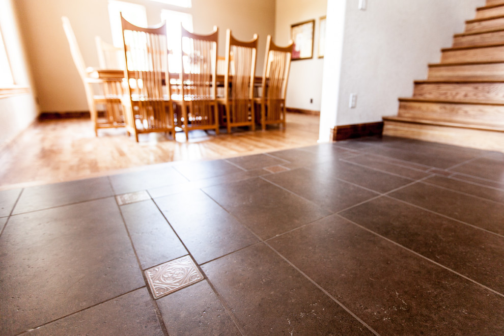 Mid-sized mountain style porcelain tile and black floor foyer photo in Omaha with beige walls and a black front door