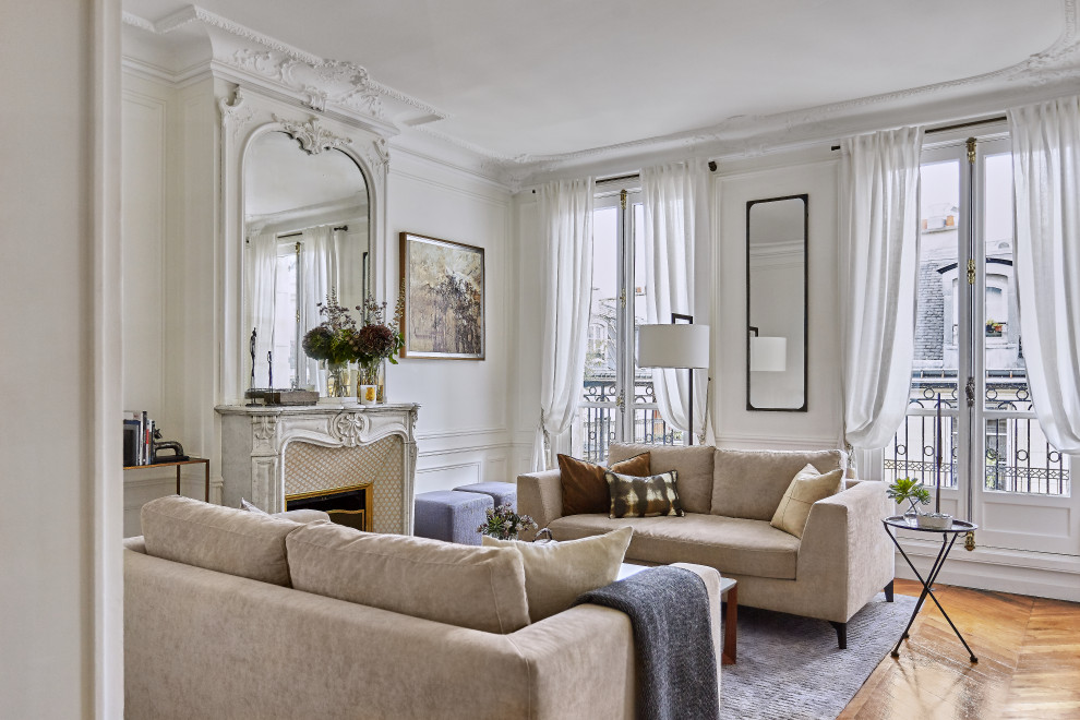 Design ideas for a transitional enclosed living room in Paris with white walls, medium hardwood floors, a standard fireplace, brown floor and panelled walls.
