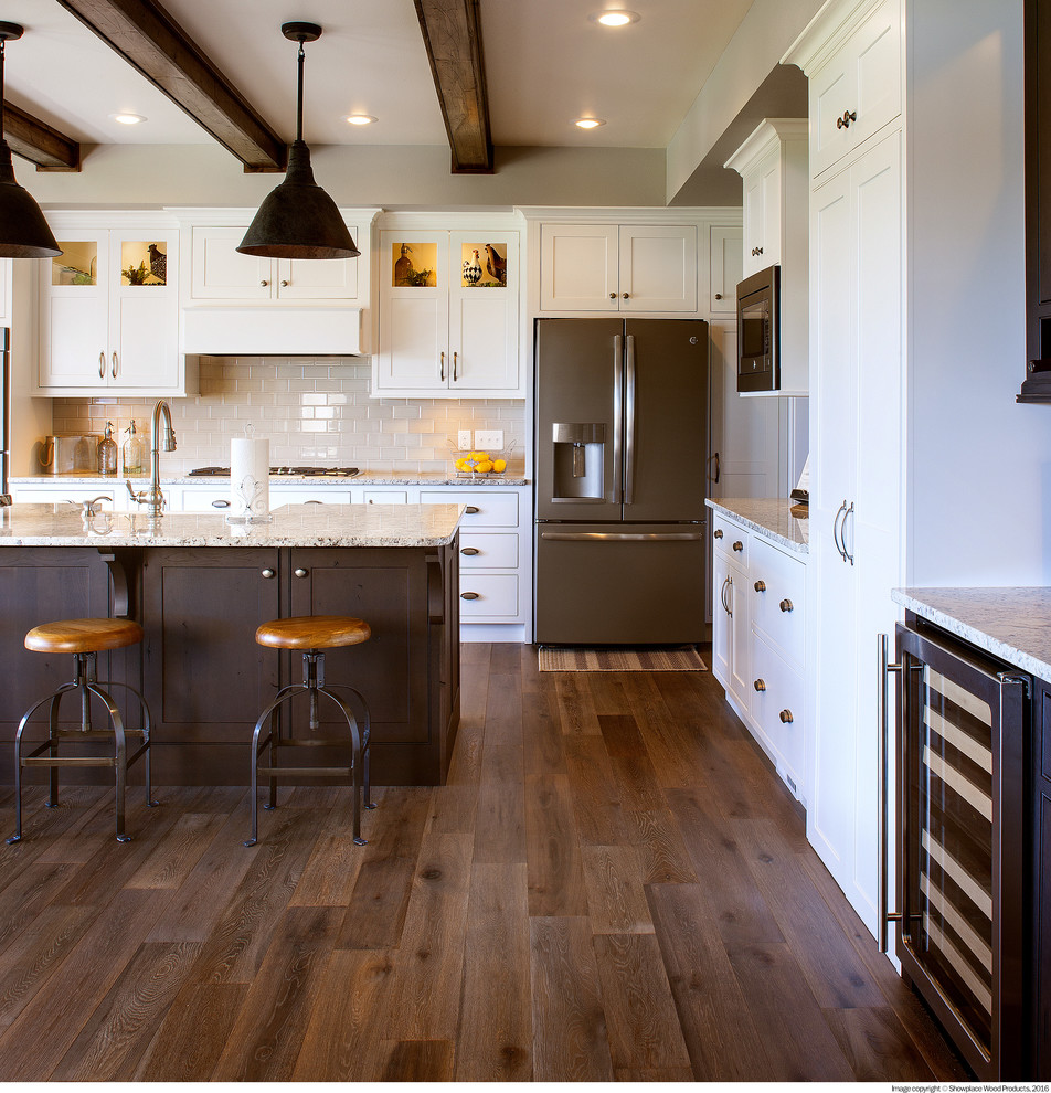 Inspiration for a transitional u-shaped dark wood floor and brown floor kitchen remodel in Tampa with shaker cabinets, white cabinets, beige backsplash, stainless steel appliances, an island and gray countertops