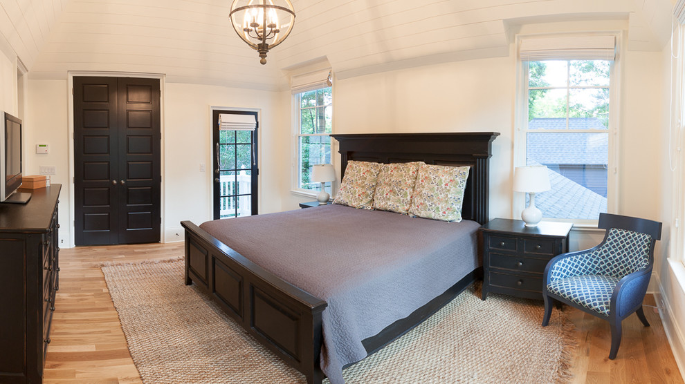 Design ideas for a large transitional master bedroom in Charlotte with white walls and light hardwood floors.