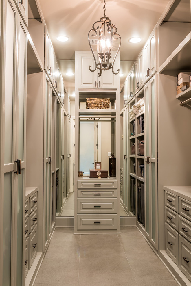 Inspiration for an expansive transitional gender-neutral walk-in wardrobe in Other with raised-panel cabinets, brown cabinets, porcelain floors and brown floor.