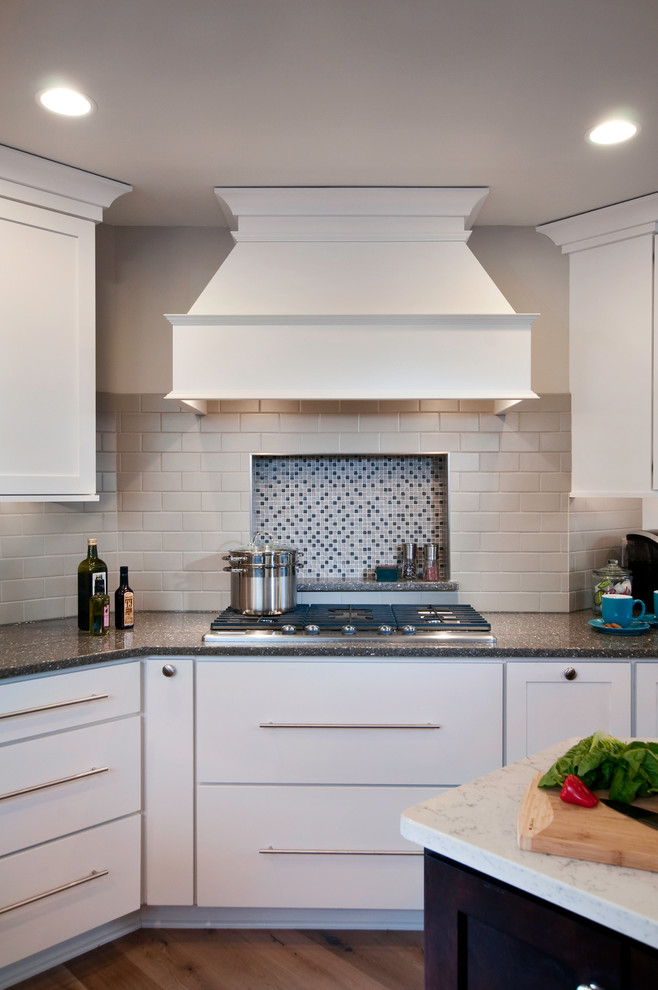 Photo of an expansive transitional l-shaped eat-in kitchen in Philadelphia with shaker cabinets, white cabinets and mosaic tile splashback.