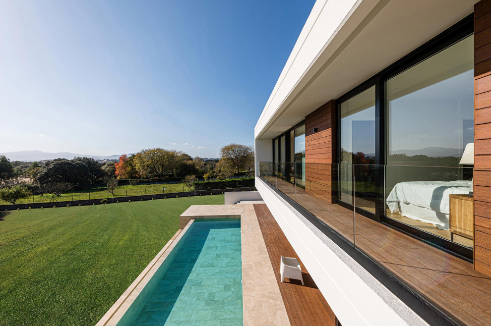 Inspiration pour une grande terrasse au premier étage minimaliste avec un garde-corps en verre.