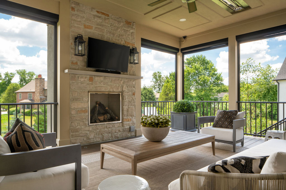 Mid-sized transitional metal railing back porch idea in Columbus with a fireplace and a roof extension