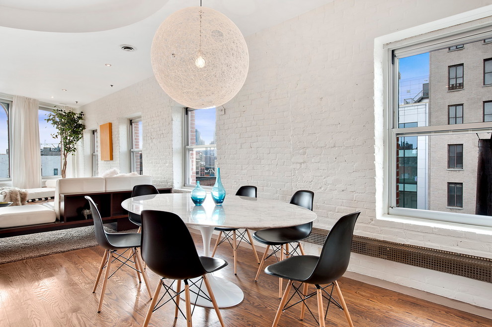 Design ideas for a contemporary dining room in New York with white walls and dark hardwood floors.