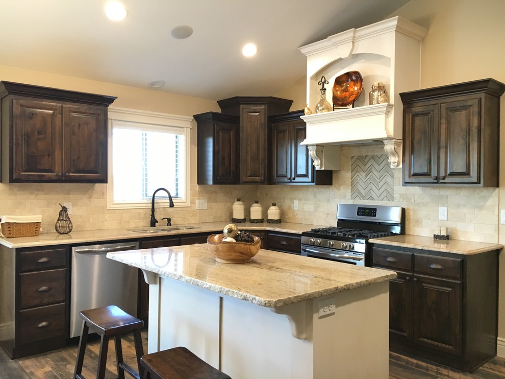 Open concept kitchen - large transitional u-shaped porcelain tile open concept kitchen idea with an undermount sink, raised-panel cabinets, dark wood cabinets, granite countertops, beige backsplash, stone tile backsplash, stainless steel appliances and an island