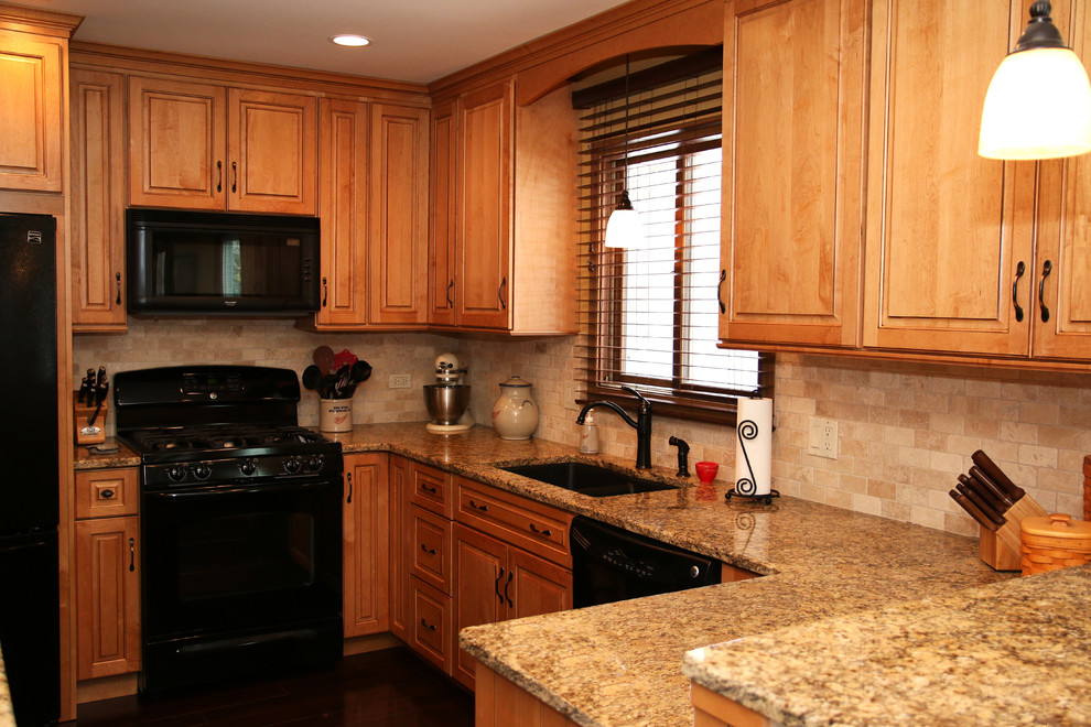 Example of a small transitional u-shaped laminate floor open concept kitchen design in Chicago with an undermount sink, raised-panel cabinets, medium tone wood cabinets, granite countertops, beige backsplash, subway tile backsplash, black appliances, black walls and a peninsula