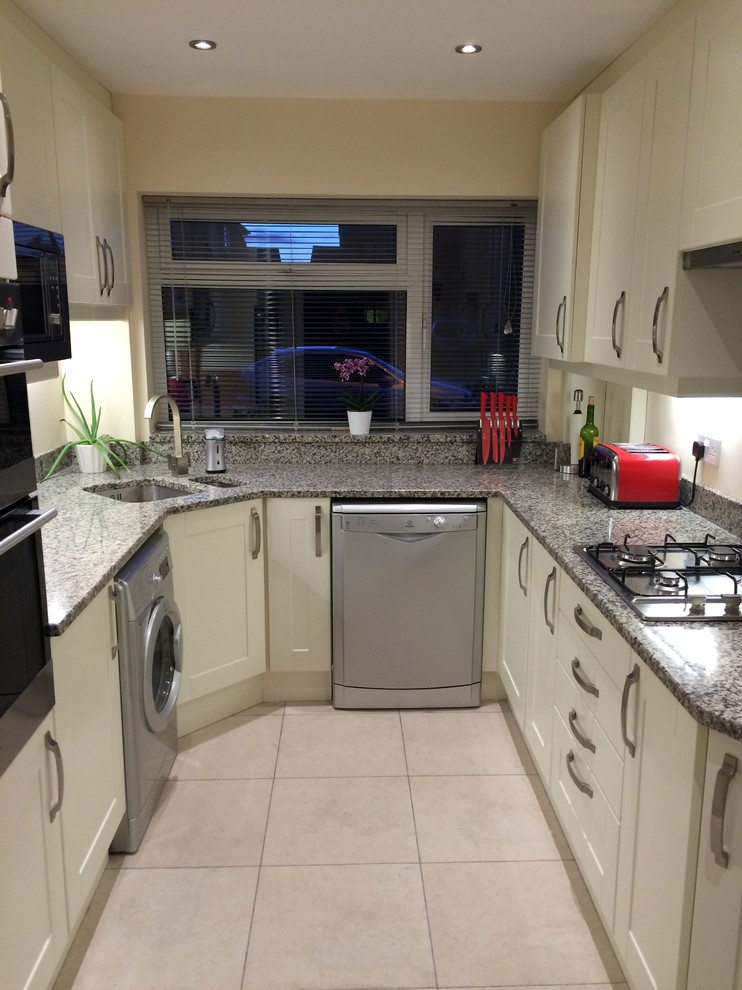 Photo of a small traditional u-shaped enclosed kitchen with an integrated sink, shaker cabinets, granite worktops, stainless steel appliances and no island.