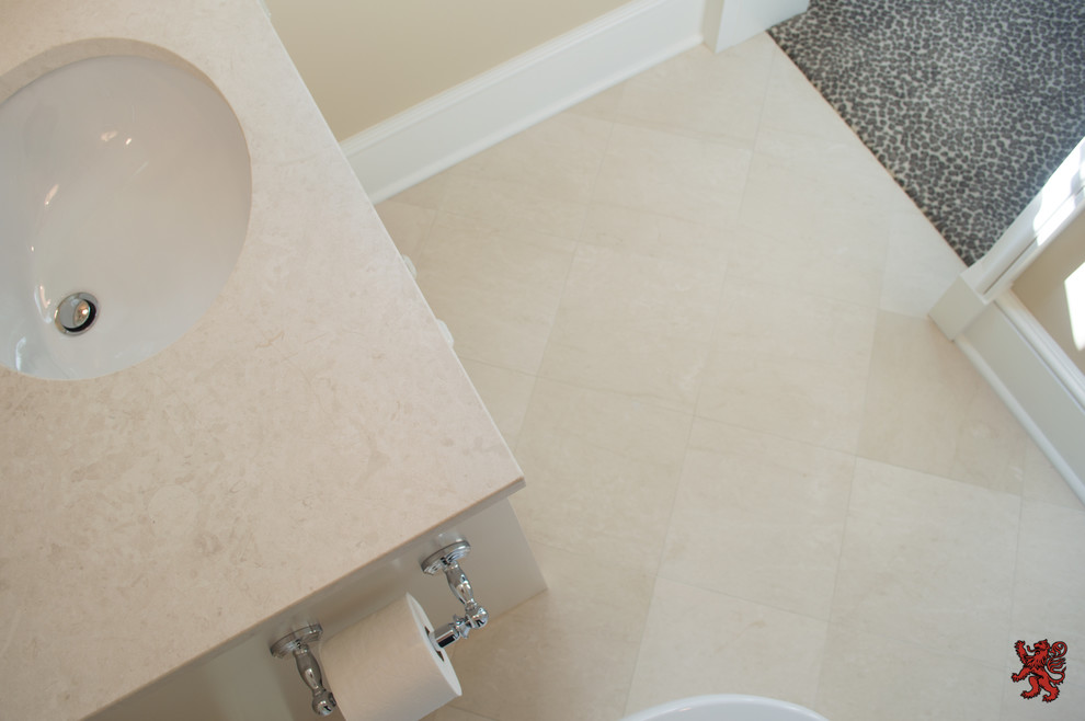 Immagine di una stanza da bagno tradizionale con top in pietra calcarea, vasca/doccia, piastrelle beige, piastrelle in pietra e pavimento in pietra calcarea