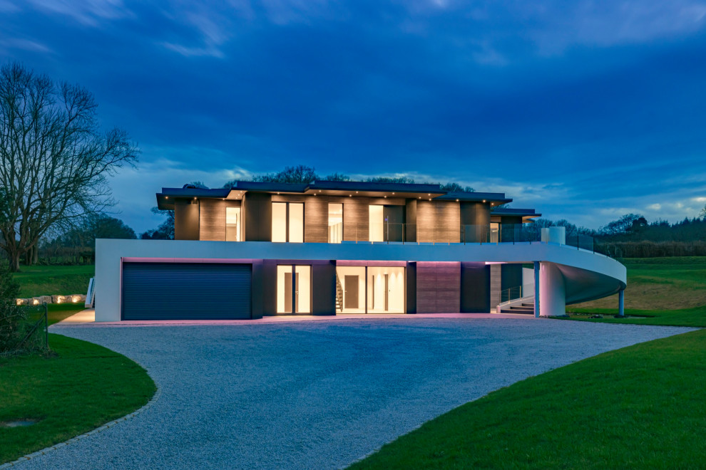 Cette image montre une grande façade de maison multicolore design en planches et couvre-joints à un étage avec un revêtement mixte, un toit plat, un toit mixte et un toit gris.