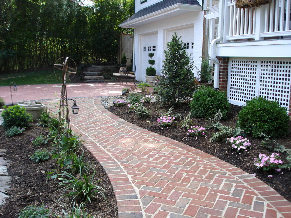 Design ideas for a mid-sized traditional front yard partial sun formal garden in DC Metro with brick pavers.