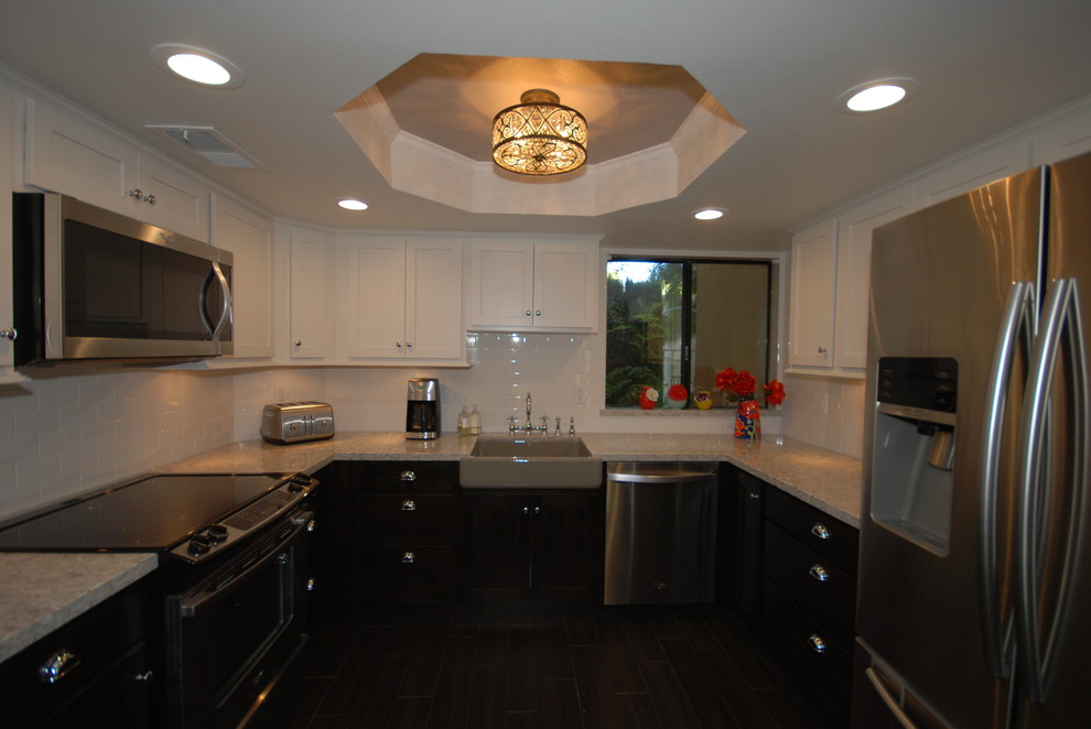 Eat-in kitchen - small transitional u-shaped porcelain tile eat-in kitchen idea with a farmhouse sink, shaker cabinets, white cabinets, quartz countertops, white backsplash, subway tile backsplash, stainless steel appliances and gray walls