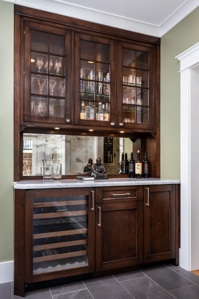 Aménagement d'une cuisine encastrable craftsman en bois brun fermée et de taille moyenne avec plan de travail en marbre, une crédence miroir, îlot, un sol gris et un plan de travail blanc.