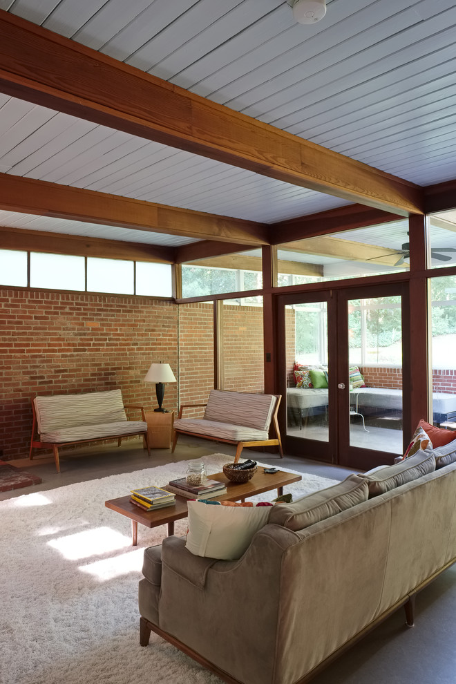 Photo of a mid-sized midcentury open concept living room in Atlanta with a wood stove and a brick fireplace surround.