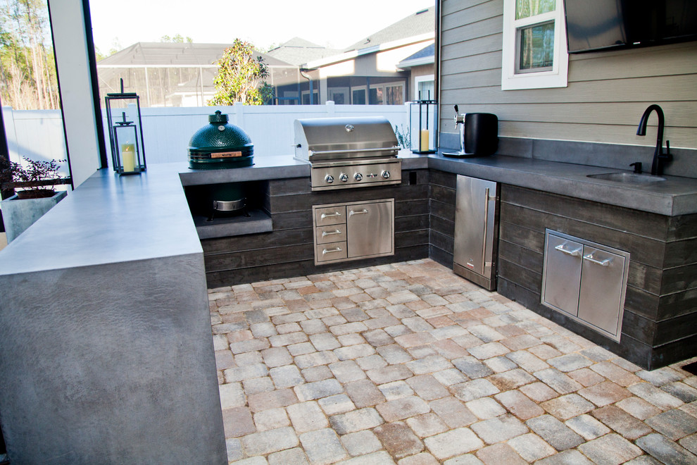 Photo of a mid-sized modern backyard patio in Jacksonville with an outdoor kitchen and brick pavers.