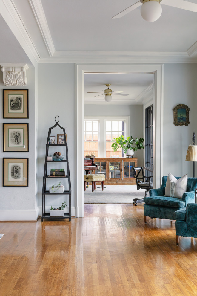 Mittelgroßes, Offenes Wohnzimmer mit blauer Wandfarbe, hellem Holzboden, braunem Boden und eingelassener Decke in Dallas