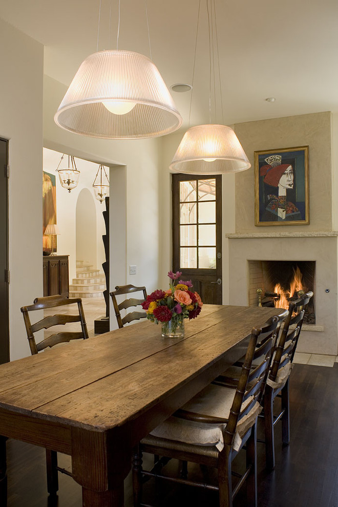 Photo of a country dining room in Austin with white walls, dark hardwood floors and a standard fireplace.