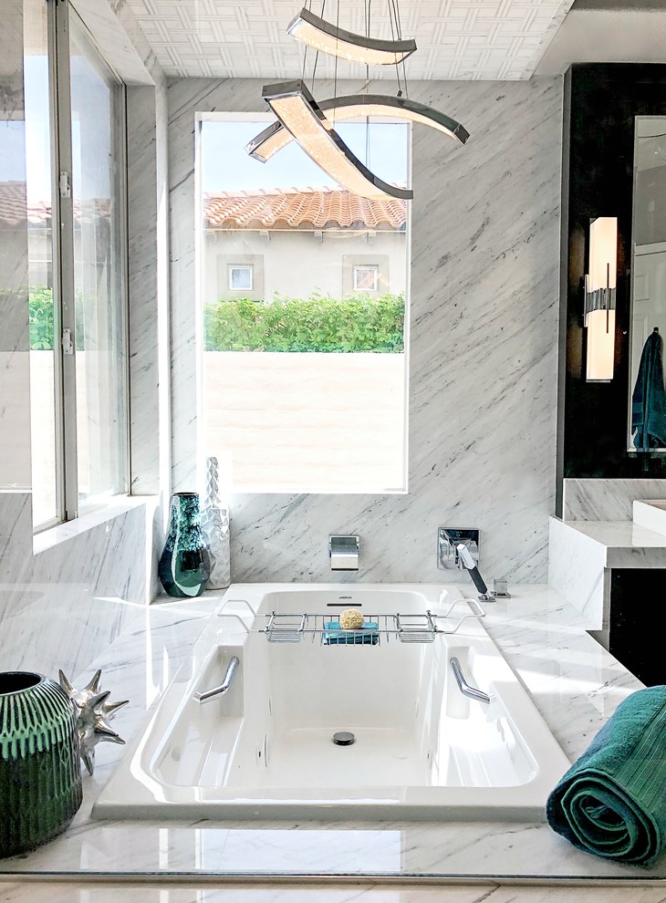 This is an example of a mid-sized contemporary master bathroom in Los Angeles with flat-panel cabinets, dark wood cabinets, a drop-in tub, a shower/bathtub combo, white tile, marble, grey walls, mosaic tile floors, a vessel sink, marble benchtops, white floor, a hinged shower door and white benchtops.