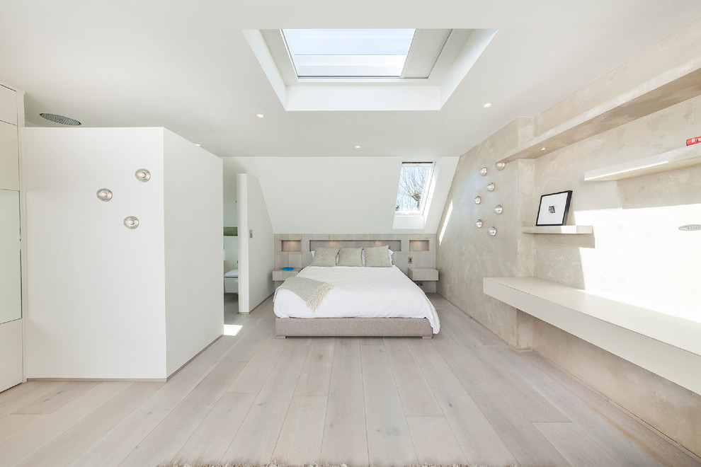 Photo of a mid-sized contemporary guest bedroom in London with beige walls, light hardwood floors and no fireplace.