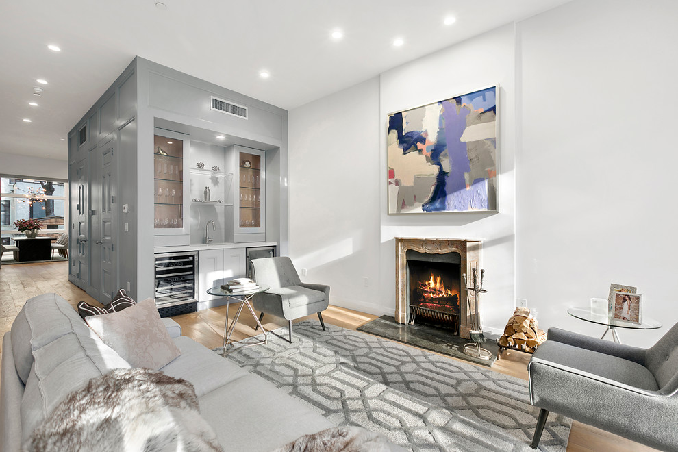 Mid-sized contemporary formal open concept living room in New York with white walls, light hardwood floors, a standard fireplace, a stone fireplace surround, no tv and brown floor.