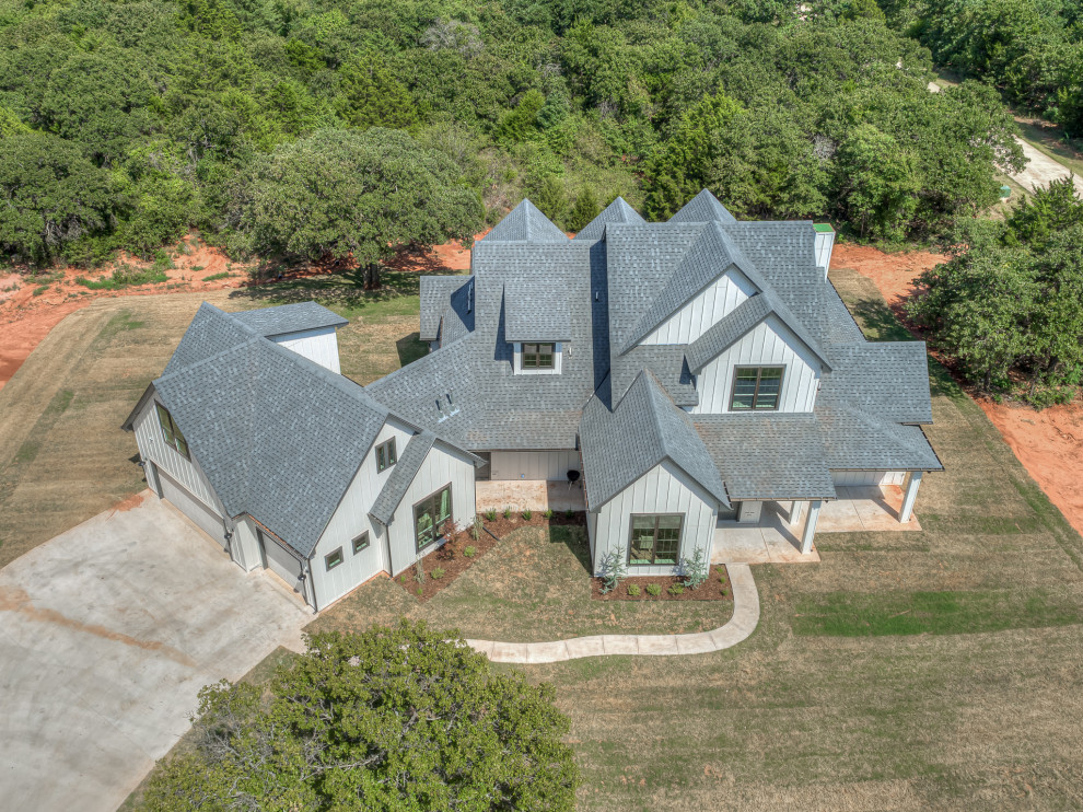 Inspiration for a large and white farmhouse two floor detached house in Oklahoma City with vinyl cladding, a pitched roof, a shingle roof, a grey roof and shingles.