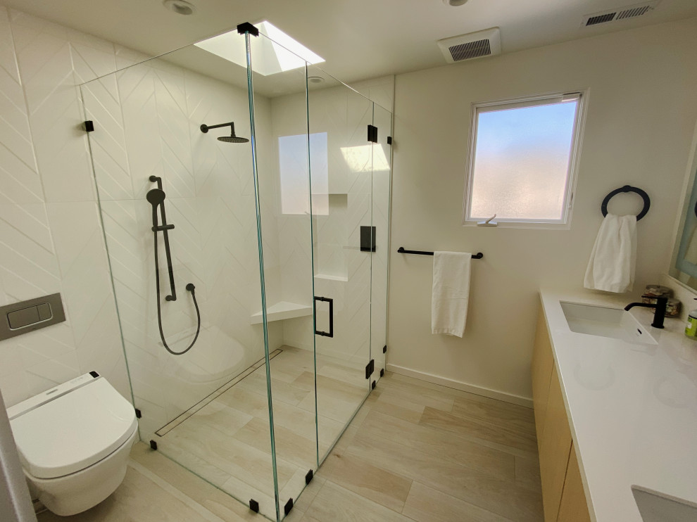 Design ideas for a mid-sized contemporary master bathroom in San Francisco with flat-panel cabinets, light wood cabinets, a curbless shower, a wall-mount toilet, white tile, porcelain tile, white walls, porcelain floors, an undermount sink, engineered quartz benchtops, beige floor, a hinged shower door, white benchtops, a niche, a double vanity and a floating vanity.