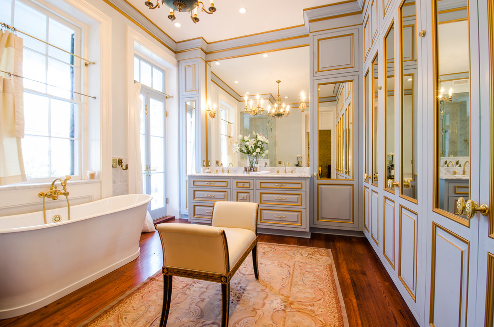 This is an example of a large traditional master bathroom in Charleston with a freestanding tub, dark hardwood floors and raised-panel cabinets.