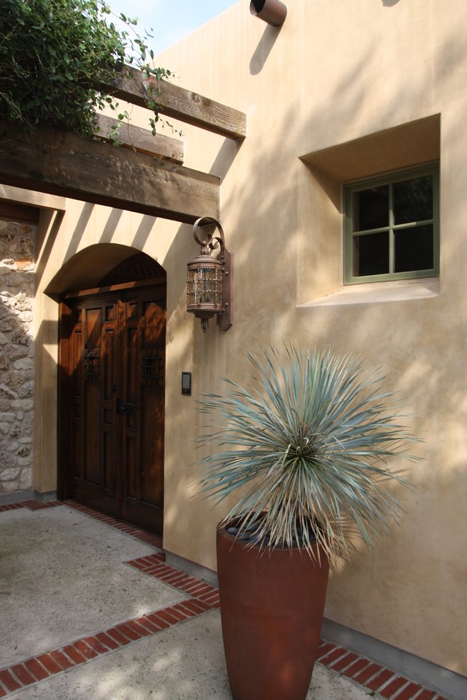 Inspiration for a mediterranean entryway in Austin with a dark wood front door.