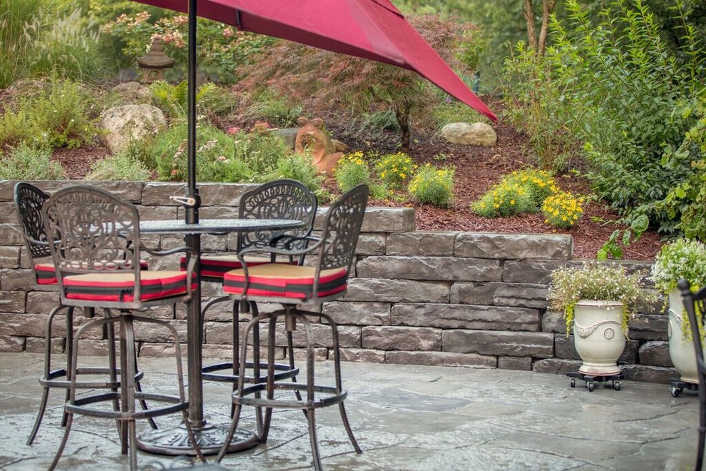 Design ideas for a mid-sized traditional backyard patio in Chicago with natural stone pavers.