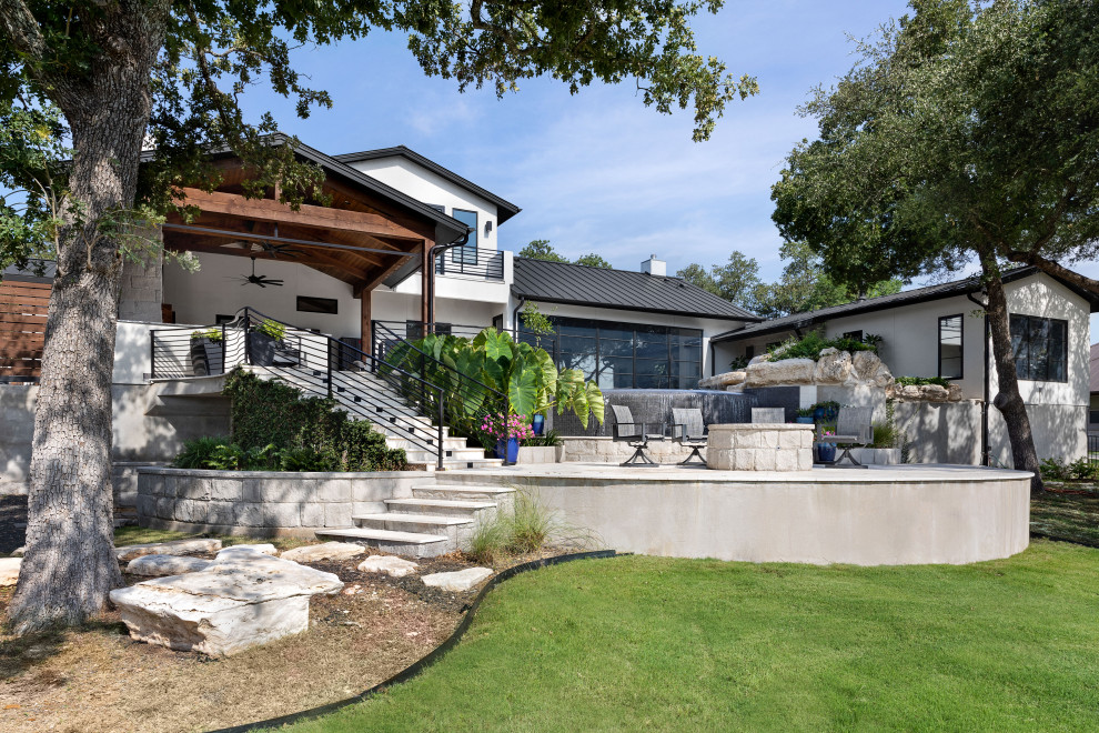 Inspiration for a modern two-storey stucco white house exterior in Austin with a black roof.