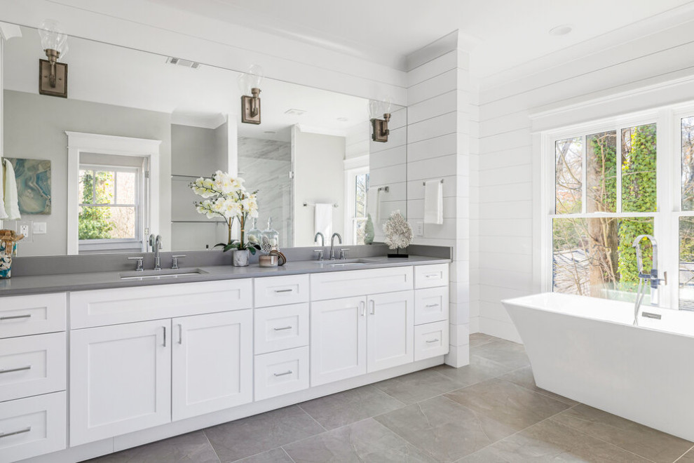 This is an example of a large transitional master bathroom in Atlanta with shaker cabinets, white cabinets, a freestanding tub, an alcove shower, a two-piece toilet, gray tile, ceramic tile, grey walls, ceramic floors, an undermount sink, quartzite benchtops, white floor, white benchtops, a niche, a single vanity and a freestanding vanity.