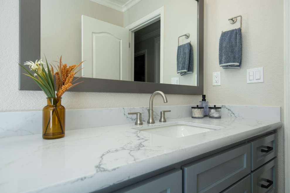 Inspiration for a modern bathroom in Sacramento with shaker cabinets, blue cabinets, an undermount tub, a shower/bathtub combo, an undermount sink, engineered quartz benchtops, a sliding shower screen, a single vanity and a built-in vanity.